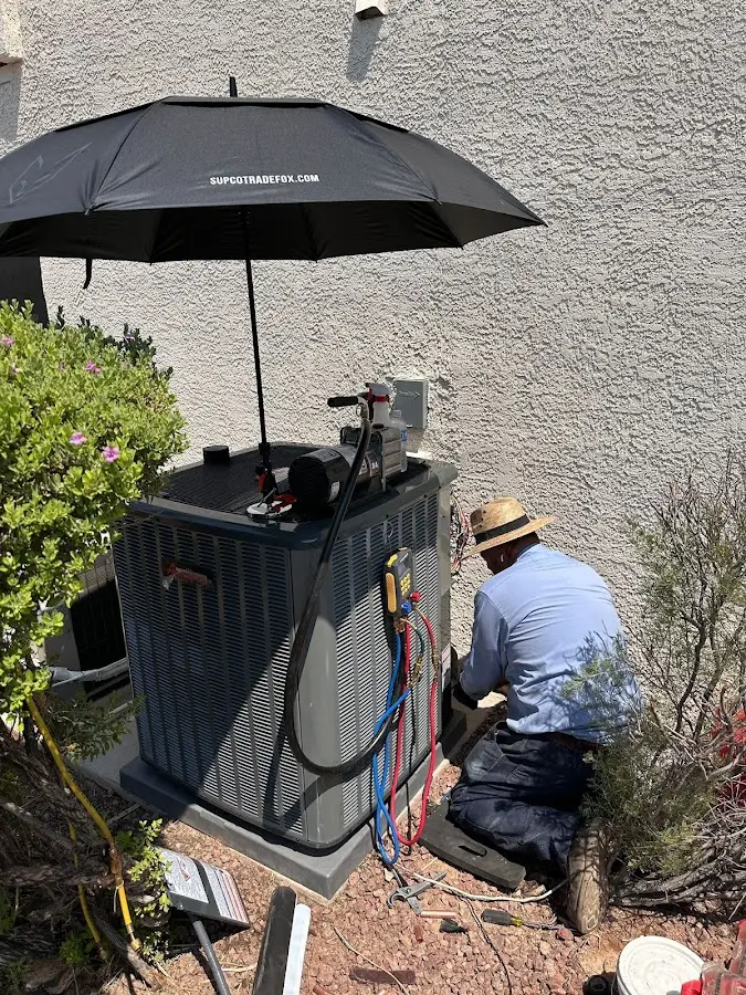 HVAC technician performing outdoor AC maintenance in Bedford
